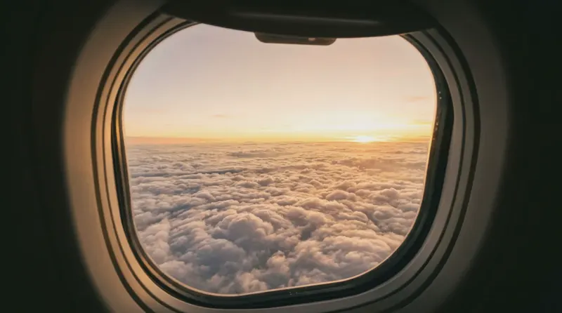 The view from a window seat above the clouds at sunrise